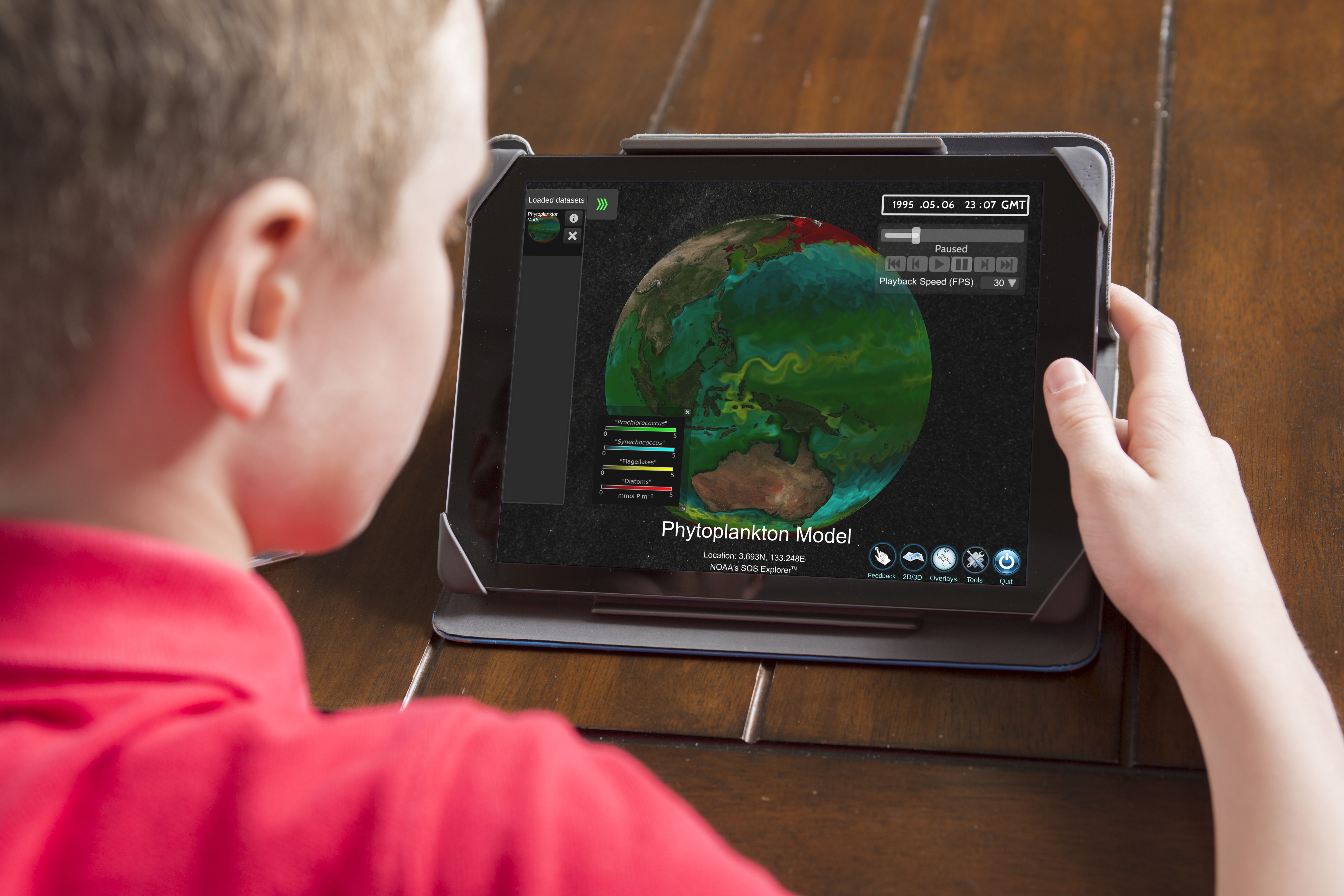 A young person views phytoplankton patterns on SOS Explorer Mobile using an iPad