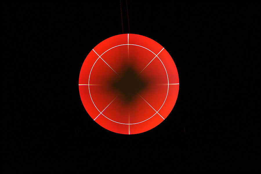 The black hole at the bottom of Science On a Sphere appears as a dark diamond while SOS displays the red ball for aligning projectors