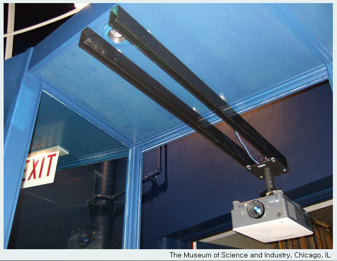 A projector is mounted to a short pole that is attached to two rails mounted into the ceiling