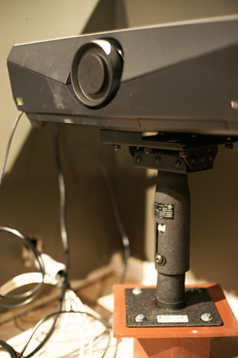 A short stand holds up a projector