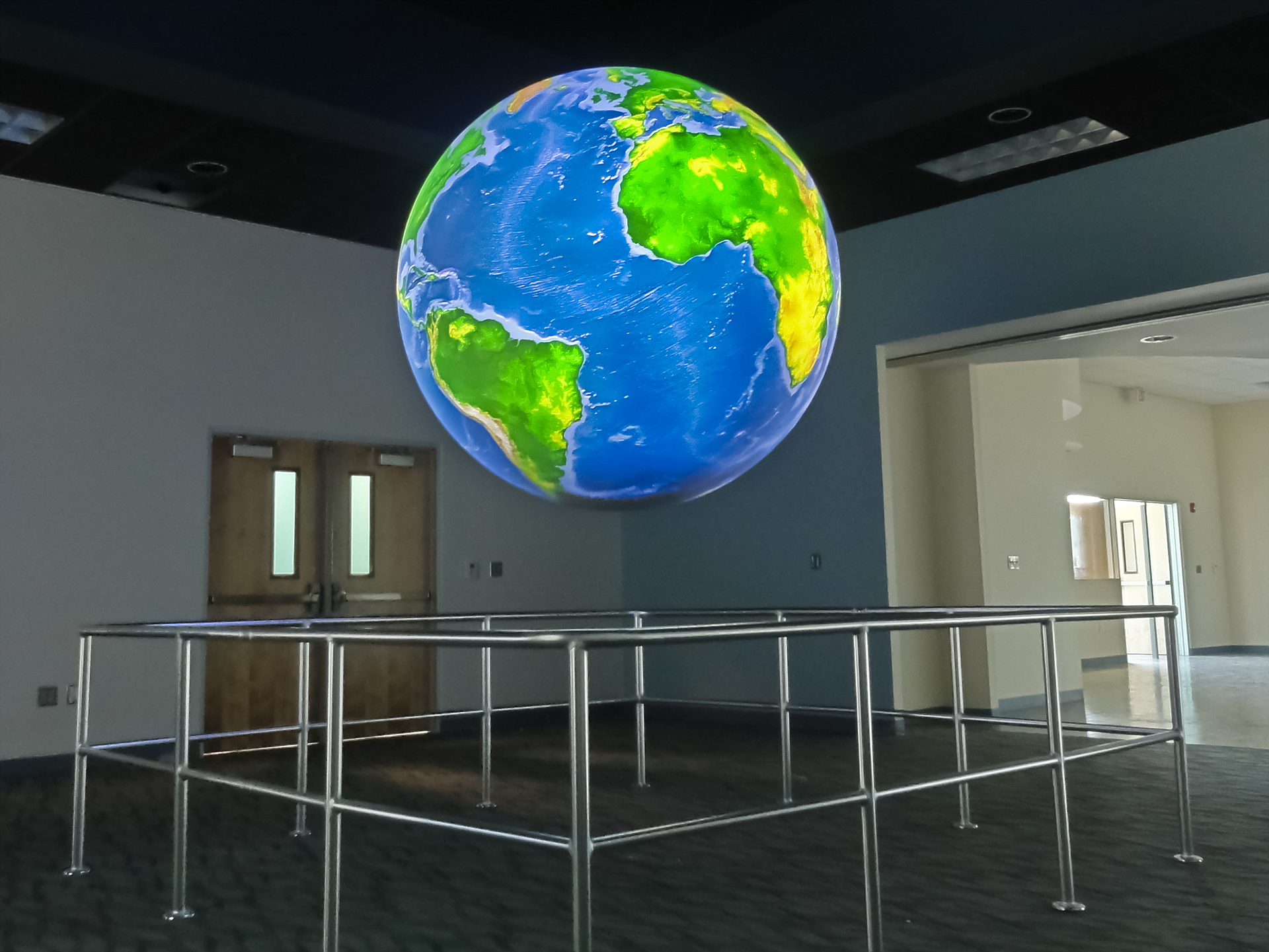 Science On a Sphere displays a shaded relief image of the ocean floor in an empty room