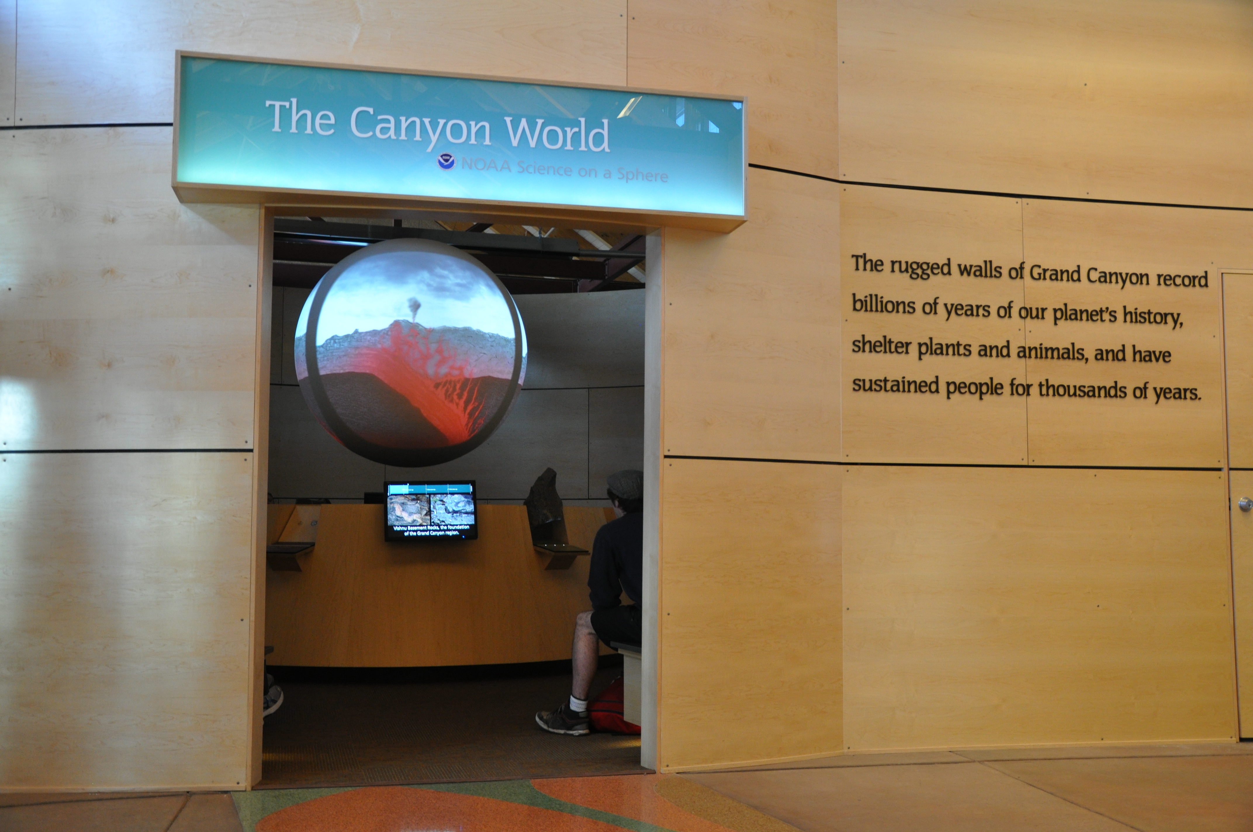 Science On a Sphere is visible through a doorway beneath a sign that read 'The Canyon World: NOAA Science On a Sphere'