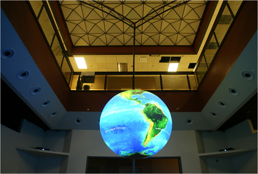 Science On a Sphere hangs from the ceiling two stories up into an empty room. It is surrounded above by a balcony on the second floor